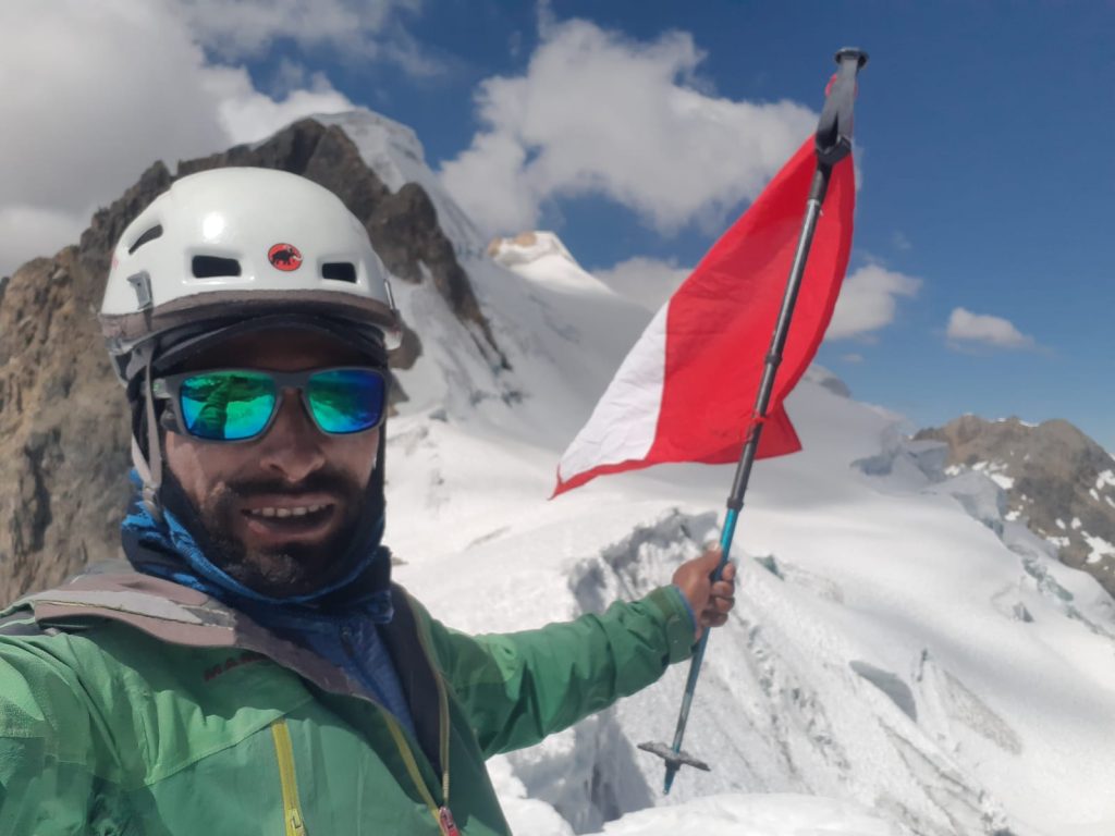 Renzzo Dario León Zubia en la cumbre del Sullcon con la bandera del Perú. 